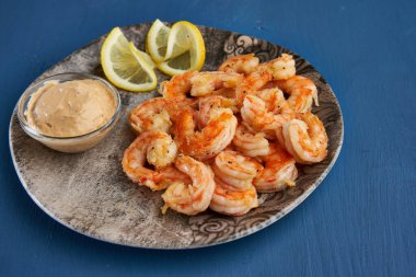 Lezzetli kırmızı kral karidesleri wok 'ta mavi arka planda hazırlandı.