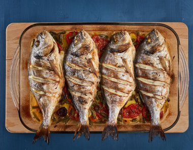 Oven baked broiled bream with vegetables and lemon