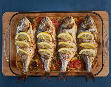 Oven baked broiled bream with vegetables and lemon