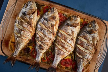 Oven baked broiled bream with vegetables and lemon