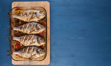 Oven baked broiled bream with vegetables and lemon