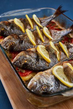 Oven baked broiled bream with vegetables and lemon