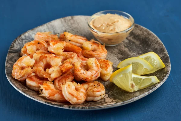 Lezzetli kırmızı kral karidesleri wok 'ta mavi arka planda hazırlandı.