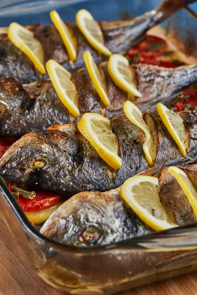 Oven baked broiled bream with vegetables and lemon