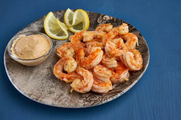 Lezzetli kırmızı kral karidesleri wok 'ta mavi arka planda hazırlandı.