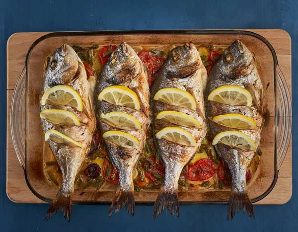 Oven baked broiled bream with vegetables and lemon