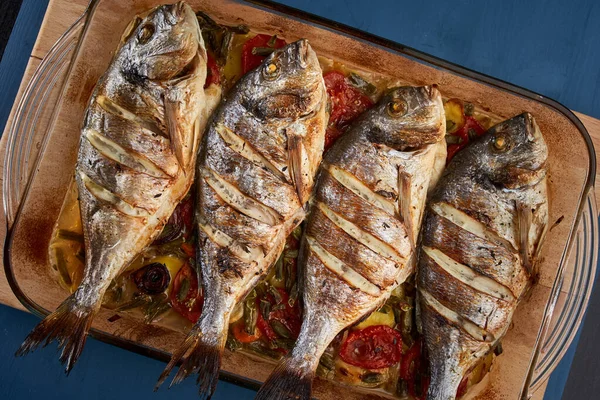 Oven baked broiled bream with vegetables and lemon