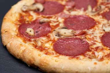 Lezzetli taze pişmiş pepperoni pizzası, ahşap bir tahtanın üzerinde fırından yeni çıktı.