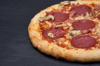 Lezzetli taze pişmiş pepperoni pizzası, ahşap bir tahtanın üzerinde fırından yeni çıktı.