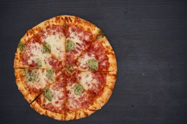 Lezzetli taze pişmiş pizza, ahşap bir tahtanın üzerinde fırından yeni çıktı.