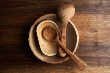 Bir ceviz tahtası üzerinde ahşap mutfak aletlerinin masa üstü resmi