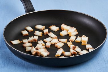 Kızartma tavasında doğranmış domuz eti.