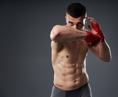 Dövüş sanatları eğitimi, dirsek atışı, gri arka planda izole edilmiş.