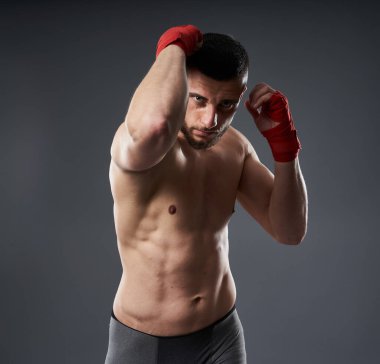 Dövüş sanatları eğitimi, dirsek atışı, gri arka planda izole edilmiş.