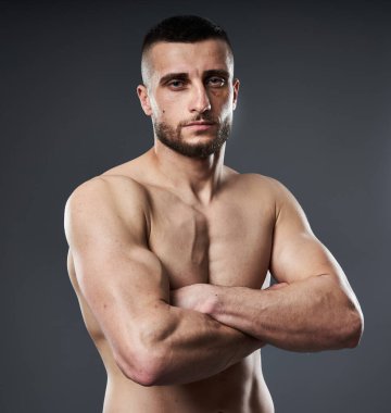 MMA dövüşçüsü, gri arka plan için poz veriyor.