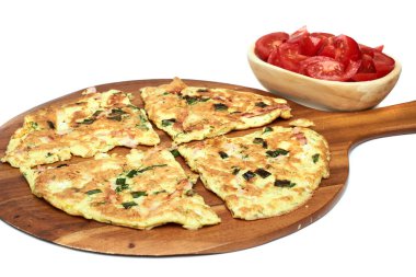 Dereotlu omlet, taze soğan ve jambon ahşap bir tabakta servis ediliyor, beyaz arka planda izole edilmiş.