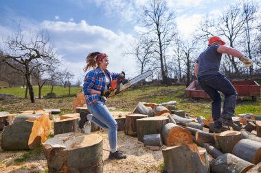 Kadın, kocasını elektrikli testereyle kovalıyor, oynaşıyor.