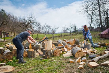 Arka bahçede kayın ağacı kıran bir çift.