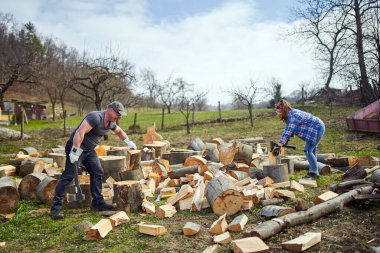 Arka bahçede kayın ağacı kıran bir çift.