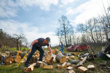 Arka bahçede kayın ağacı kıran bir çift.