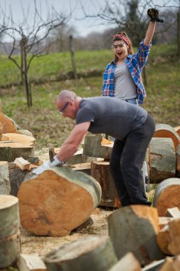 Arka bahçede kayın ağacı kıran bir çift.