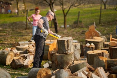 Arka bahçede kayın ağacı kıran bir çift.