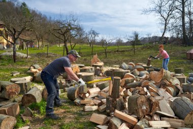 Arka bahçede kayın ağacı kıran bir çift.