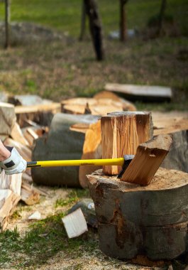 Oduncu ağır baltayla odun kırıyor.