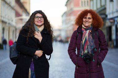 Turist kadınlar sokakta eski kasabayı geziyorlar.