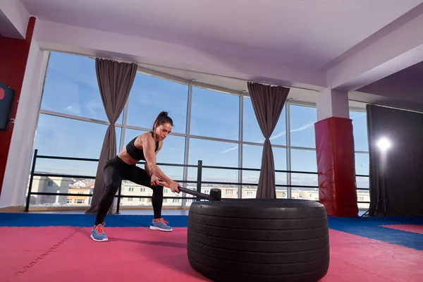 Modello Fitness Femminile Fracassare Pneumatico Enorme Con Una Sledgehammer Palestra — Foto Stock