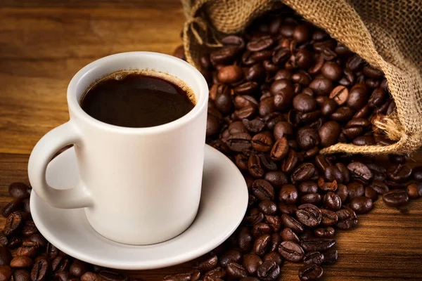 Kaffee Einer Tasse Und Geröstete Bohnen Auf Einem Holztisch Oder — Stockfoto