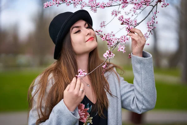公园里年轻的惊慌失措的女人 樱桃树盛开 — 图库照片
