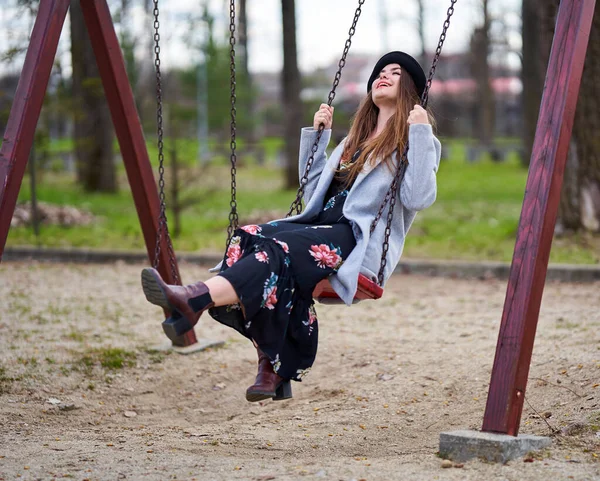 春の時間を楽しむ公園でスイングの若い女性 — ストック写真