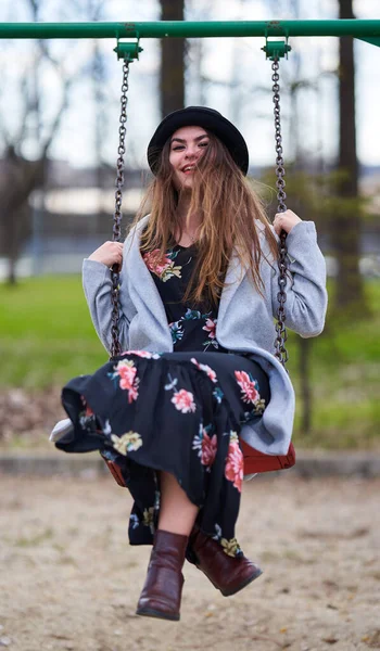 春の時間を楽しむ公園でスイングの若い女性 — ストック写真