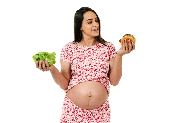 Έγκυος Γυναίκα Που Επιλέγει Ανάμεσα Μαρούλι Και Μπιφτέκι Απομονωμένη Λευκό — Φωτογραφία Αρχείου