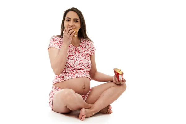 Zwangere Vrouw Hunkeren Naar Een Hamburger Portret Geïsoleerd Witte Achtergrond — Stockfoto