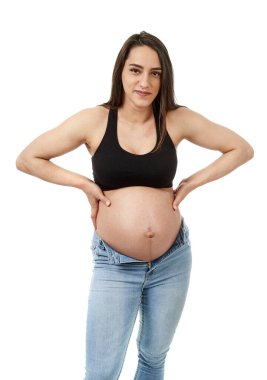 Hamile kadın dar kotundan memnun değil, beyaz arka planda soyutlanmış.