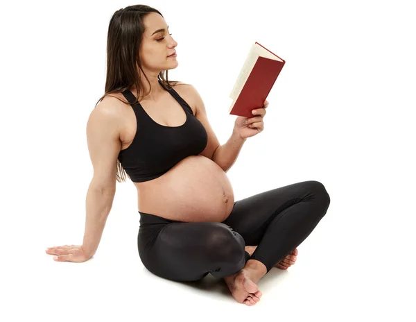 正在阅读书籍的怀孕拉丁裔妇女 与白人背景隔离 — 图库照片