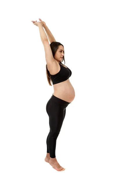 妊娠中の若い妊婦は白い背景で隔離された妊娠のための適性の練習をする — ストック写真