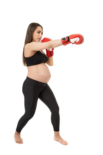 妊娠中の若い妊婦は白い背景で隔離された妊娠のための適性の練習をする — ストック写真