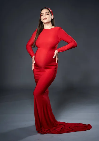 Gri Arka Planda Yalnız Poz Veren Kırmızı Elbiseli Başlıklı Güzel — Stok fotoğraf