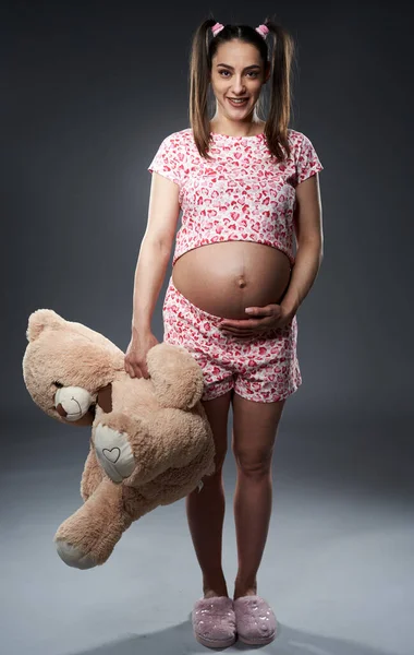 Zwangere Vrouw Pyjama Met Een Grote Pluizige Beer Speelgoed Poseren — Stockfoto