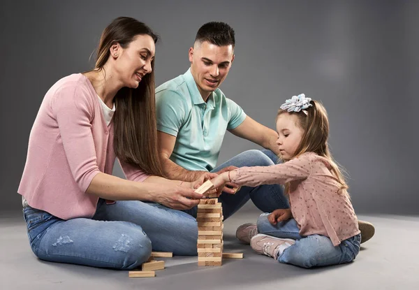 幸福的年轻家庭 父母和小女儿 工作室拍摄灰色背景 — 图库照片