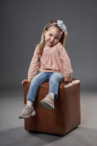 Little Adorable Girl Sitting Cube Chair Isolated Gray Background — Stock Photo, Image
