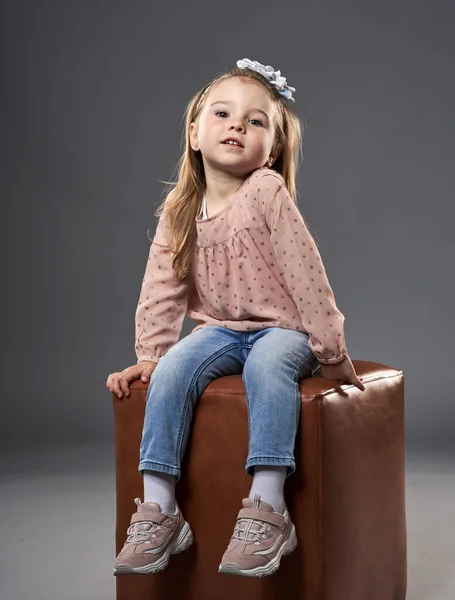 Little Adorable Girl Sitting Cube Chair Isolated Gray Background — Stock Photo, Image