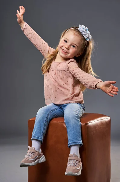 Klein Schattig Meisje Zwaaien Terwijl Zitten Een Kubus Stoel Geïsoleerd — Stockfoto