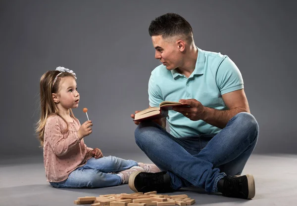 Papai Lendo Livro Para Sua Filhinha Enquanto Cubos Brinquedo Madeira — Fotografia de Stock