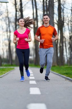 Parkta koşan atletik ve çekici genç çift