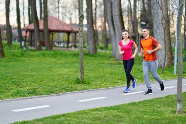 Parkta koşan atletik ve çekici genç çift