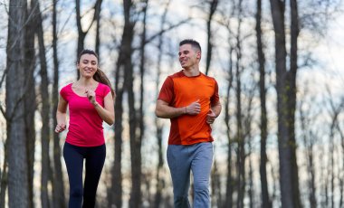 Parkta koşan atletik ve çekici genç çift